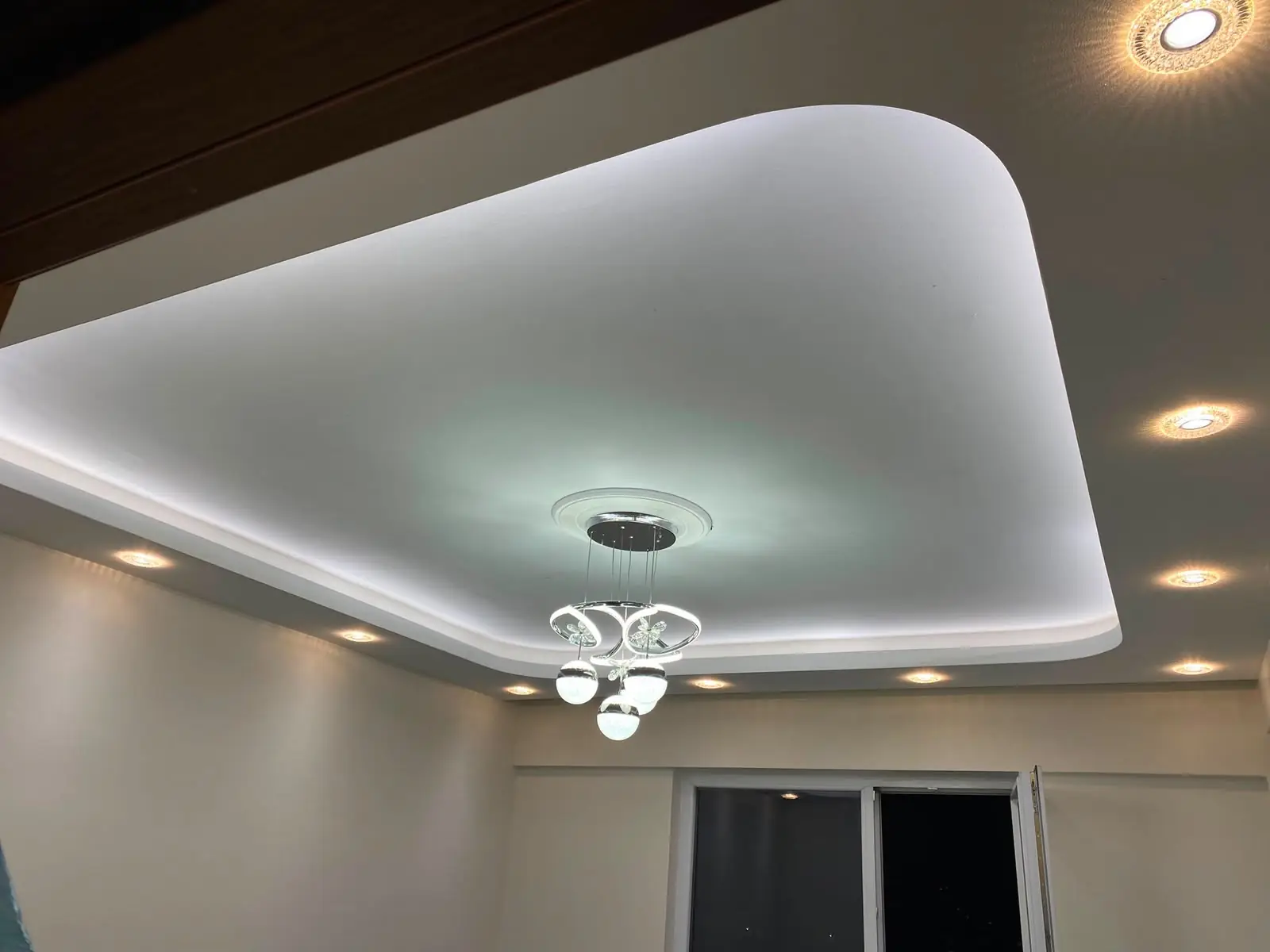 Gizli LED'li asma tavan, spot armatürler ve ortada avize