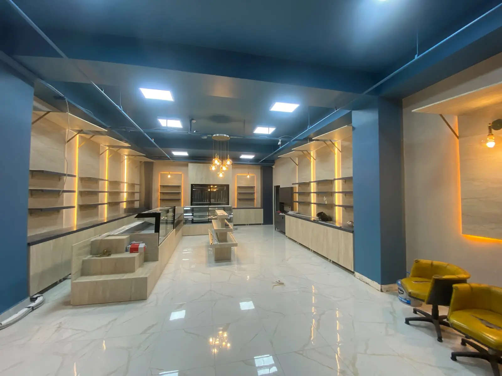 Panel LED tavan armatürleri ve raf aydınlatması yapılmış dükkân